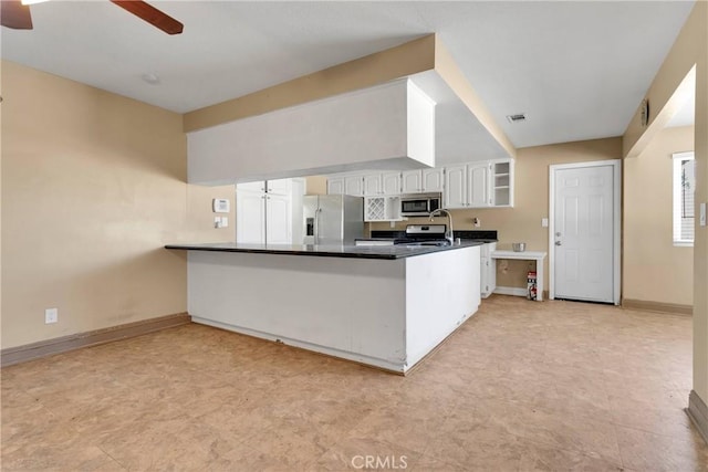 kitchen with ceiling fan, stainless steel appliances, kitchen peninsula, and white cabinets