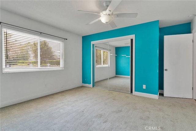 unfurnished bedroom featuring light carpet, a closet, and ceiling fan