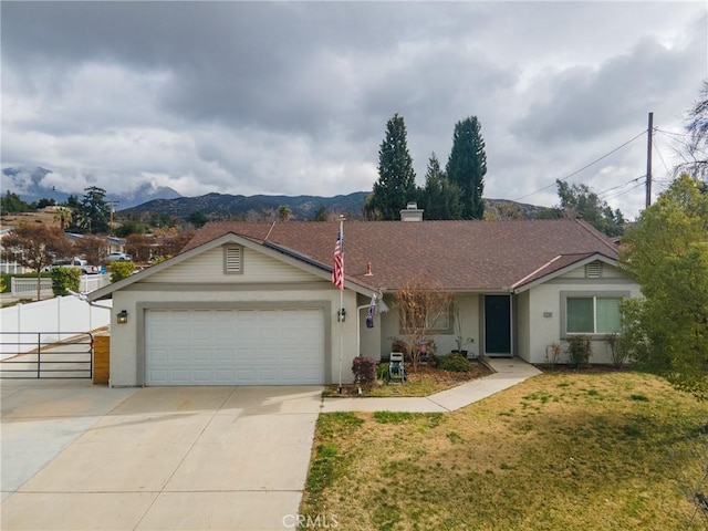 ranch-style house featuring a mountain view, a garage, and a front lawn