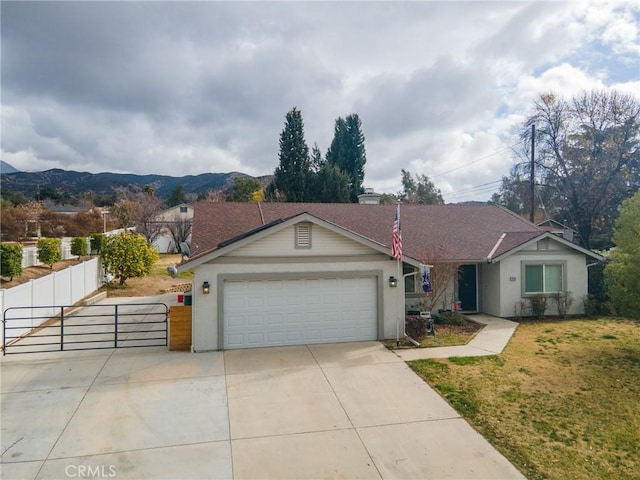 ranch-style house featuring a garage, a mountain view, and a front lawn