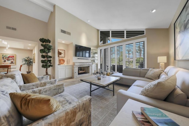 living room with a premium fireplace and high vaulted ceiling