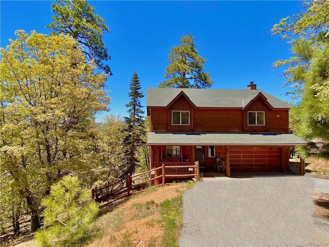 log home featuring a garage and covered porch