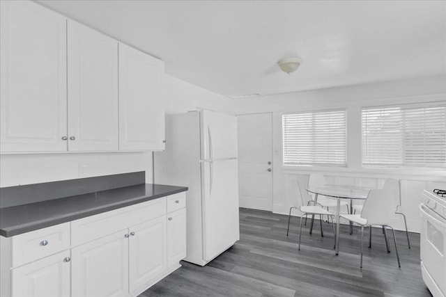 kitchen featuring white appliances, dark hardwood / wood-style floors, and white cabinets