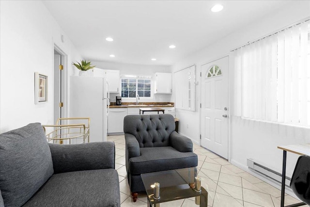 tiled living room with a baseboard radiator and sink