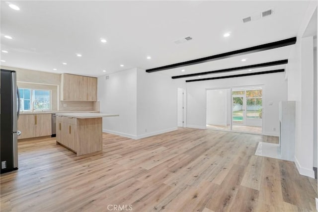 kitchen featuring open floor plan, light countertops, appliances with stainless steel finishes, a center island, and modern cabinets