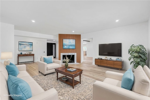 living area with light wood-type flooring, a fireplace, and recessed lighting