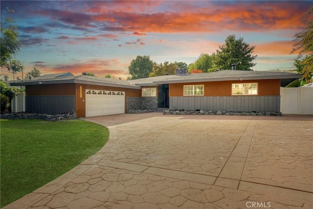 view of front facade featuring a garage, driveway, and a lawn