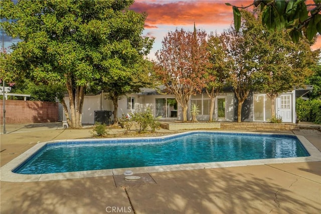 view of swimming pool featuring a patio area, fence, and a fenced in pool