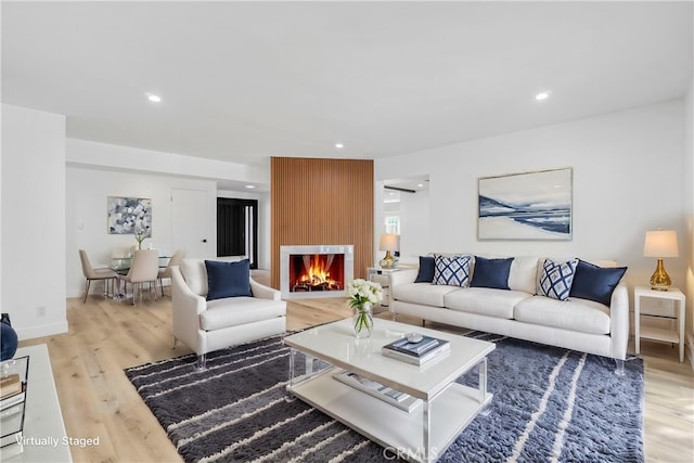 living room with light wood-style floors, recessed lighting, and a fireplace