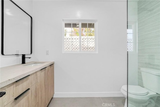 bathroom featuring toilet, tile patterned floors, vanity, and baseboards