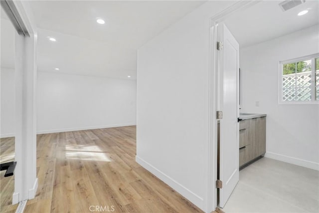 hallway with recessed lighting, visible vents, light wood finished floors, and baseboards