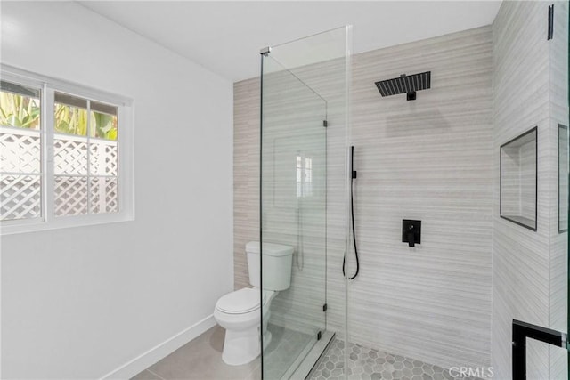 bathroom with baseboards, walk in shower, toilet, and tile patterned floors