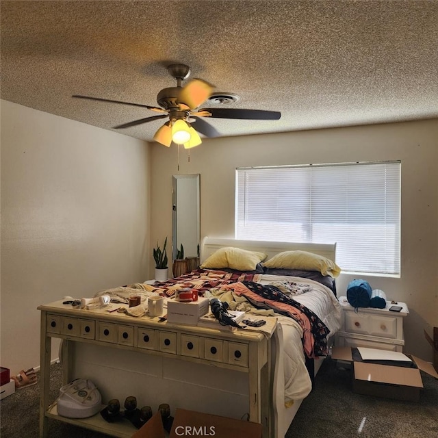 bedroom with multiple windows, ceiling fan, carpet flooring, and a textured ceiling