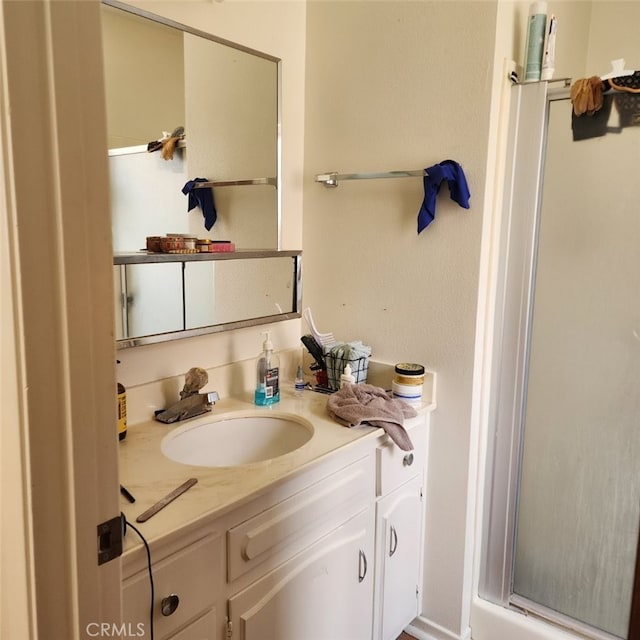 bathroom featuring vanity and a shower with door