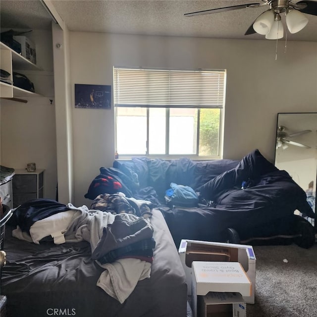 bedroom featuring ceiling fan, carpet, and a textured ceiling