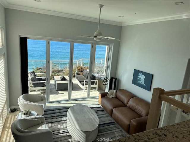 living room featuring a water view, ceiling fan, a beach view, and crown molding