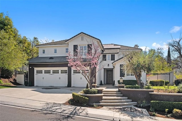 traditional-style home featuring an attached garage, roof mounted solar panels, fence, and concrete driveway