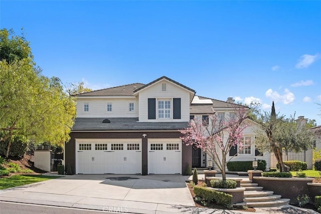 view of front of house featuring concrete driveway, an attached garage, and a tiled roof