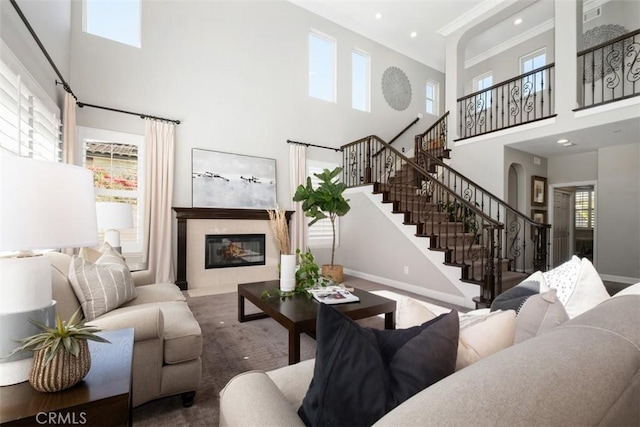 20 Bentley Rd, Coto De Caza, CA 92679 - living room featuring a high ceiling, stairs, a fireplace, baseboards, and crown molding