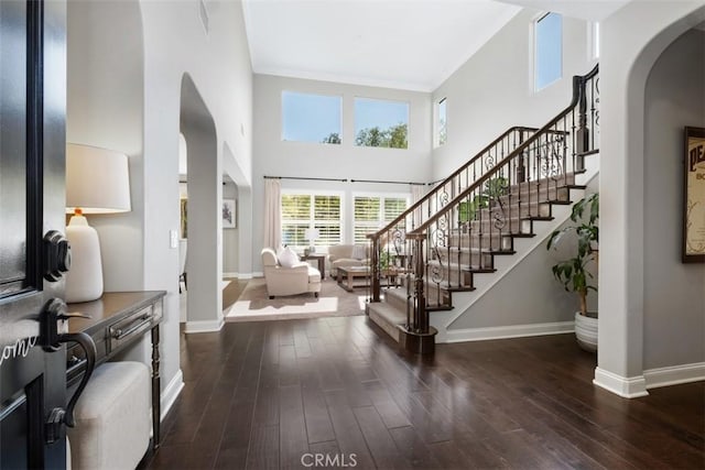 20 Bentley Rd, Coto De Caza, CA 92679 - foyer entrance featuring arched walkways, baseboards, a towering ceiling, dark wood-style flooring, and stairs