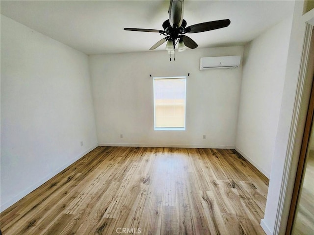 spare room featuring an AC wall unit, ceiling fan, and light wood-type flooring