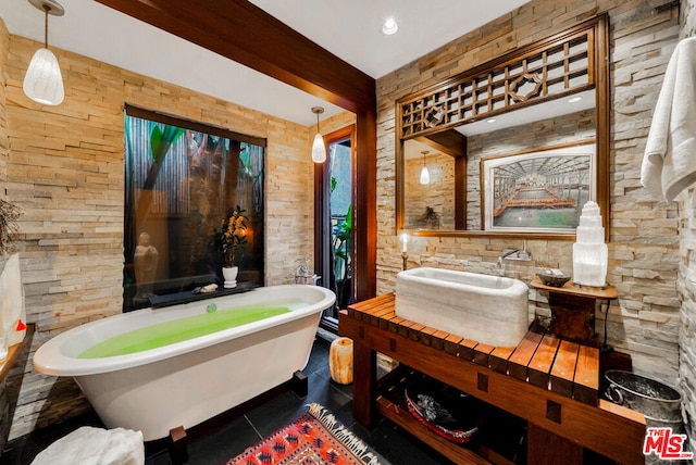 bathroom featuring tile patterned flooring, a bathing tub, vanity, and beam ceiling