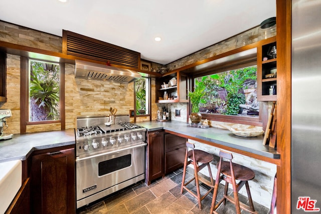 kitchen featuring tasteful backsplash, appliances with stainless steel finishes, and wall chimney range hood