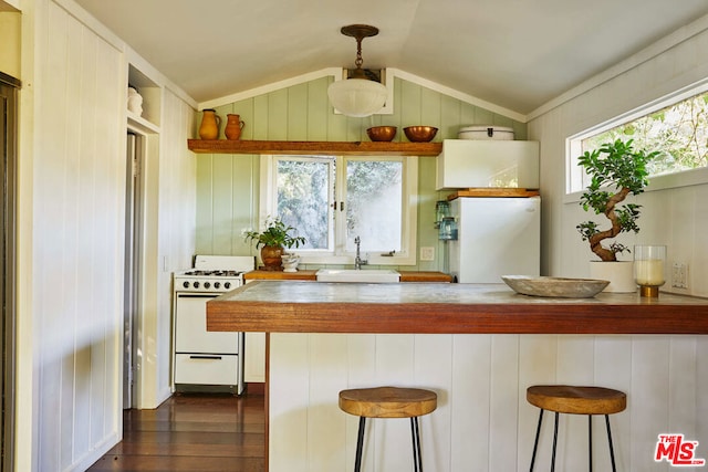 kitchen featuring sink, a breakfast bar, white gas stove, and kitchen peninsula