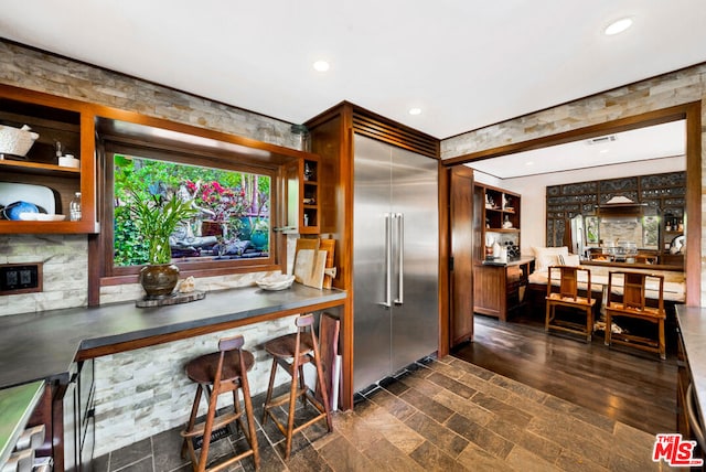 kitchen featuring stainless steel built in refrigerator and dark hardwood / wood-style flooring