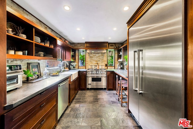 kitchen with sink, decorative backsplash, and high quality appliances