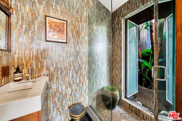 bathroom with vanity and tile walls