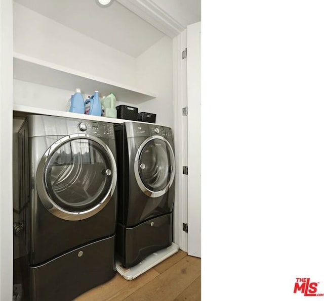 laundry room featuring hardwood / wood-style flooring and washing machine and clothes dryer