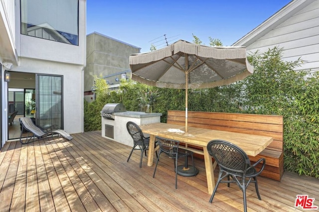 wooden deck with area for grilling and a grill