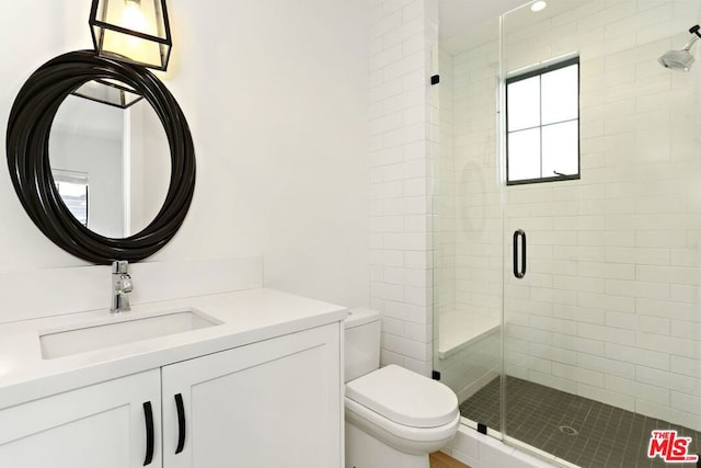 bathroom with vanity, toilet, and a shower with door