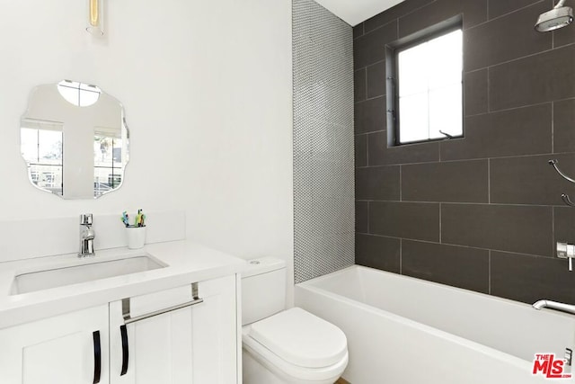 full bathroom featuring tiled shower / bath, a wealth of natural light, vanity, and toilet