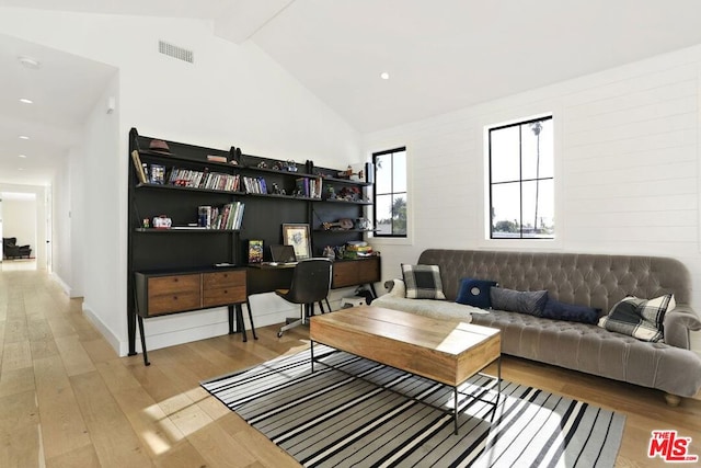 living room featuring high vaulted ceiling, hardwood / wood-style floors, and beam ceiling