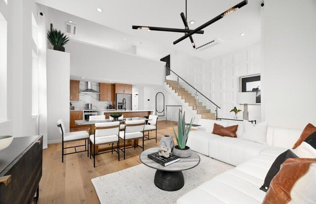 living room featuring a towering ceiling and light hardwood / wood-style floors