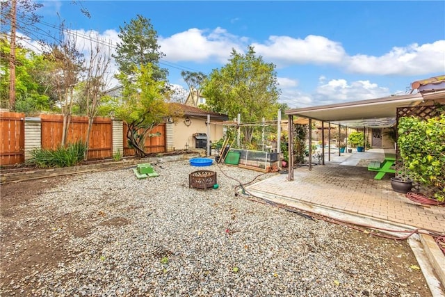 view of yard with a patio, fence, and an outdoor fire pit