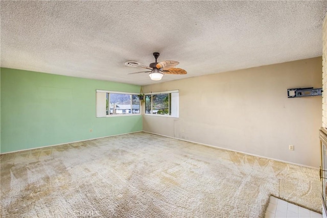 empty room featuring a textured ceiling, ceiling fan, and carpet floors