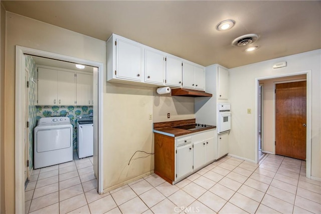 kitchen featuring oven, visible vents, washer and dryer, white cabinetry, and black electric stovetop