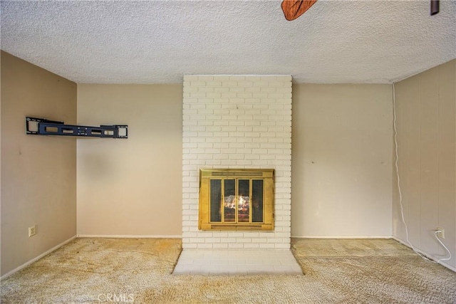 unfurnished living room with carpet floors, a textured ceiling, and a brick fireplace