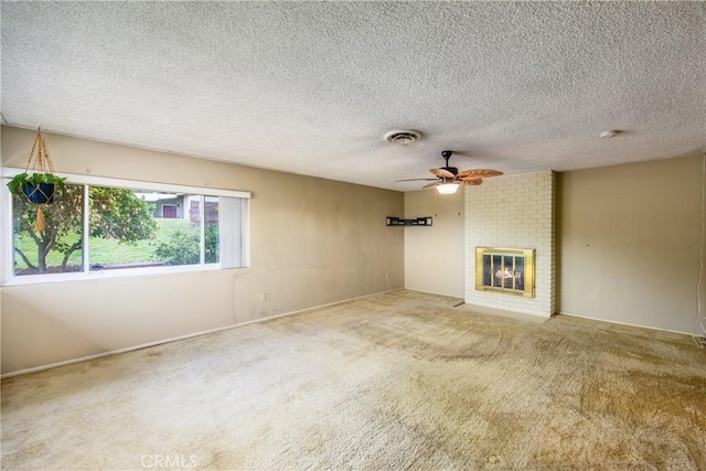 unfurnished living room with visible vents, a ceiling fan, a textured ceiling, carpet flooring, and a fireplace