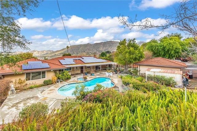 outdoor pool featuring a patio area and a mountain view