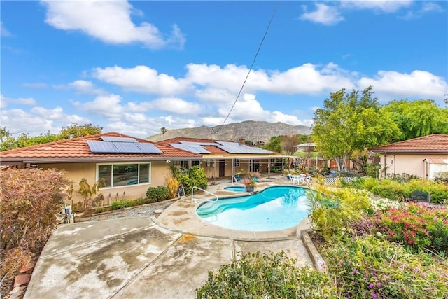 outdoor pool featuring a mountain view, an in ground hot tub, and a patio area