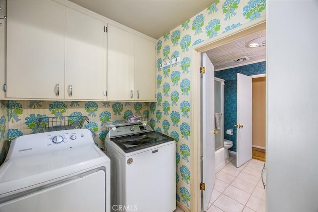 laundry room featuring visible vents, cabinet space, light tile patterned flooring, wallpapered walls, and washing machine and clothes dryer