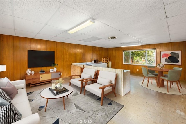 living room with visible vents, light floors, and a drop ceiling