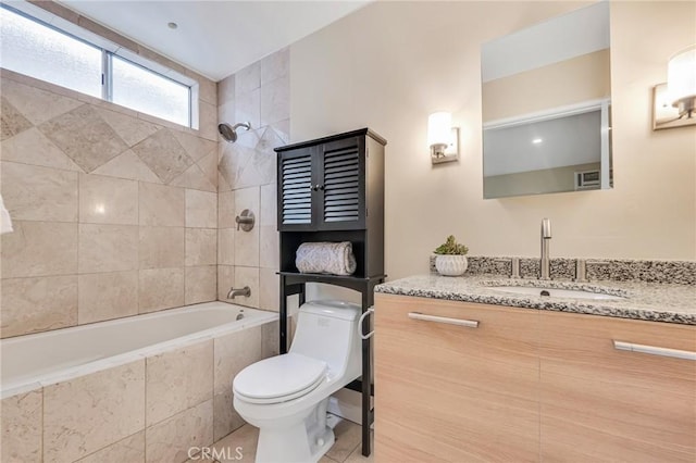 full bathroom featuring tiled shower / bath combo, vanity, tile patterned floors, and toilet