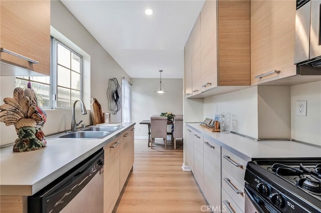 kitchen with decorative light fixtures, dishwasher, sink, black range with gas stovetop, and light hardwood / wood-style floors