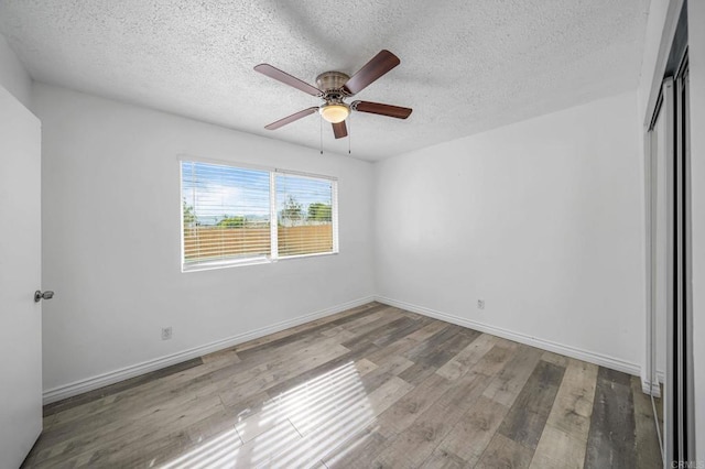 unfurnished room featuring a textured ceiling, ceiling fan, and light hardwood / wood-style flooring