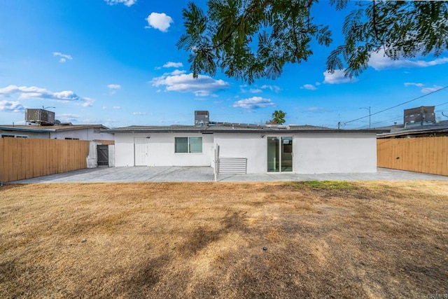 back of property featuring central AC, a patio area, and a lawn